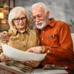 Man and woman sitting on couch looking at photo album
