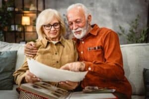 Man and woman sitting on couch looking at photo album