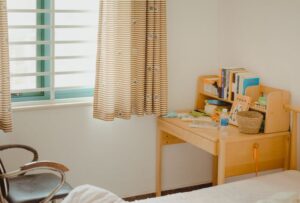 舒適的臥室角落，配有木質書桌和書架，展現專業定制傢俱設計.