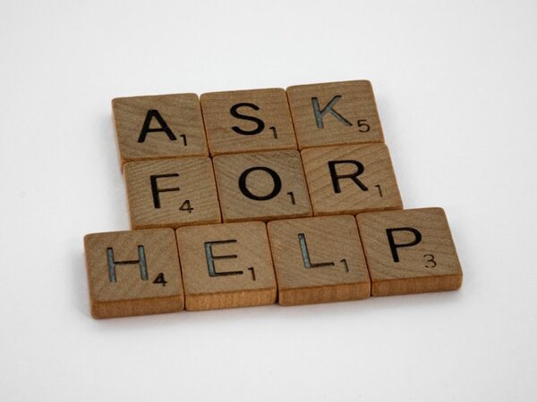 Wooden letter tiles spelling 'ASK FOR HELP'
