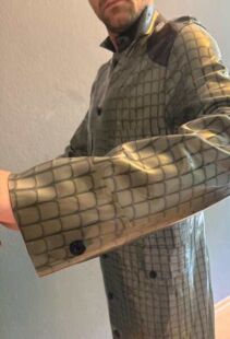 Eine Person tr&auml;gt einen PVC-Gummi-Outfit mit Netzdesign. Perfekt f&uuml;r Fetisch, BDSM und Fisting.