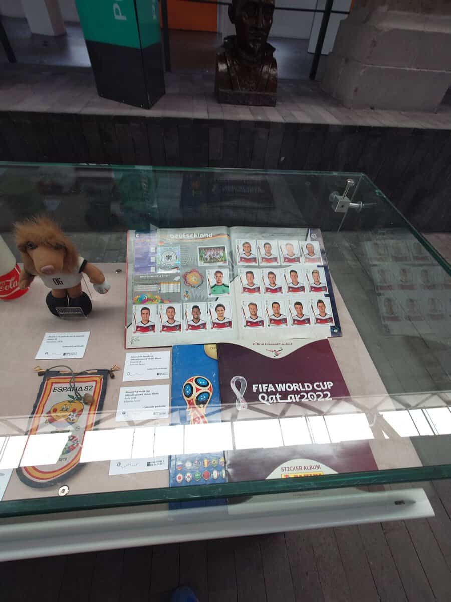 A collection of vintage World Cup freebies including coins, wallcharts and stickers laid out on a table