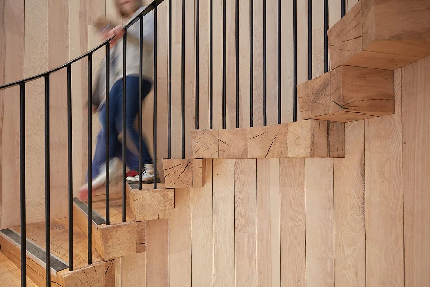 Stunning wooden staircase with sleek black metal railing in a stylish, modern interior setting.
