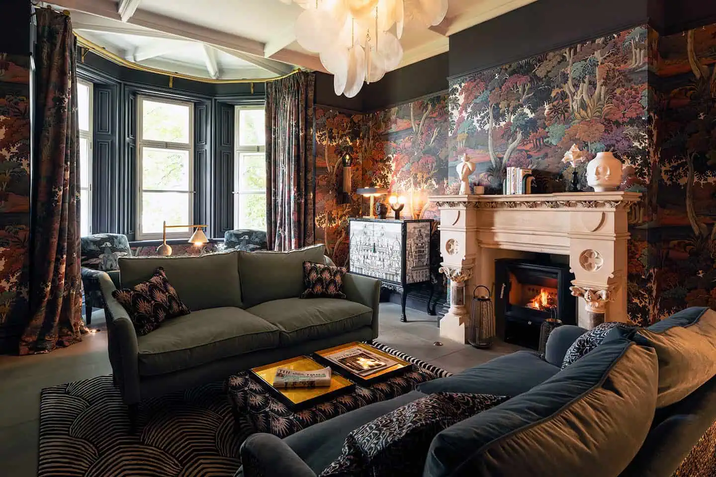 Elegant drawing room with vintage furniture, floral wallpaper, and cosy fireplace setting. Perfect f.