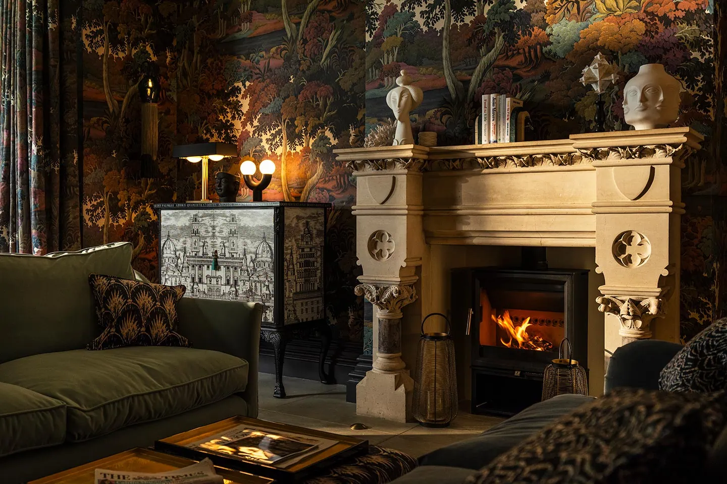 Luxurious drawing room featuring antique-style fireplace, patterned wallpaper, and cozy seating for sophisticated living.
