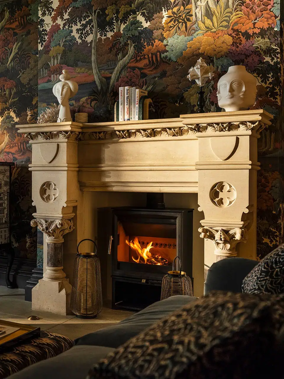 Charming drawing room featuring a classic fireplace, stylish accessories, and patterned wallpaper.