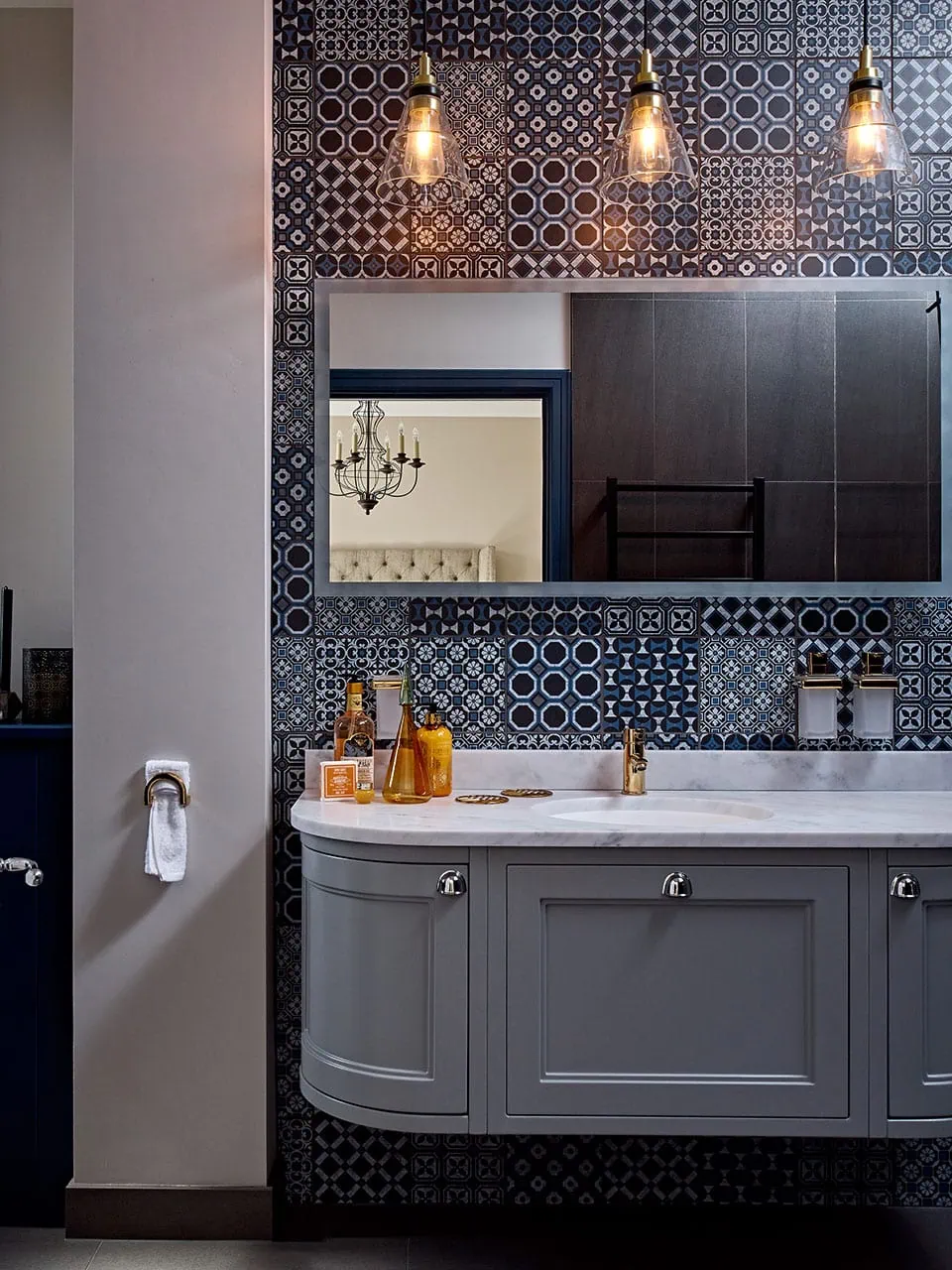 Stylish shower room featuring patterned tiles, gold fixtures, and contemporary design elements.