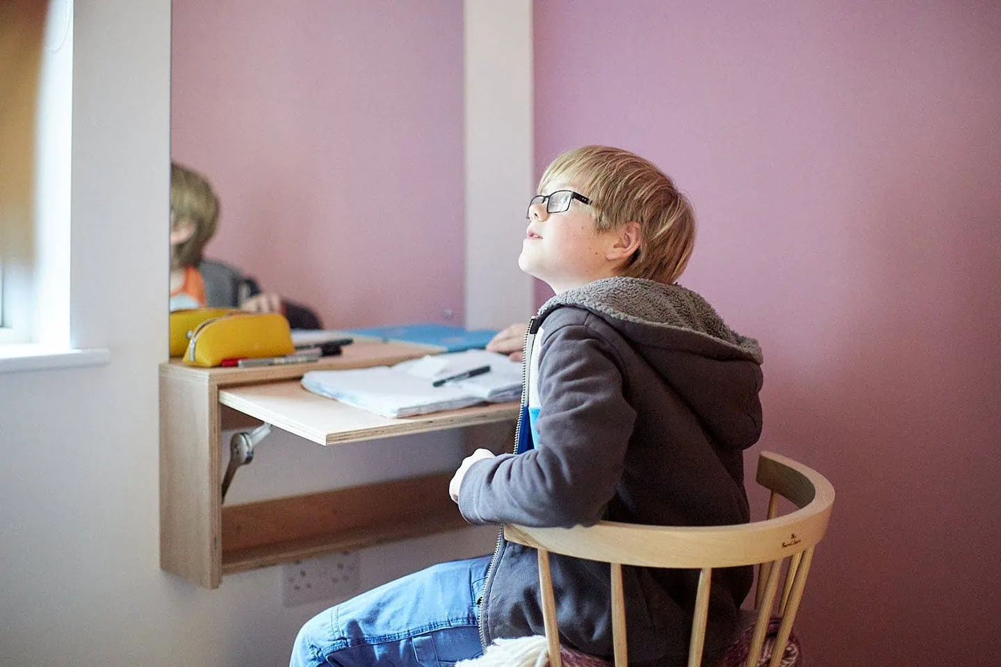 Bright study nook with a wooden desk, colourful accessories, and a comfy chair for children.