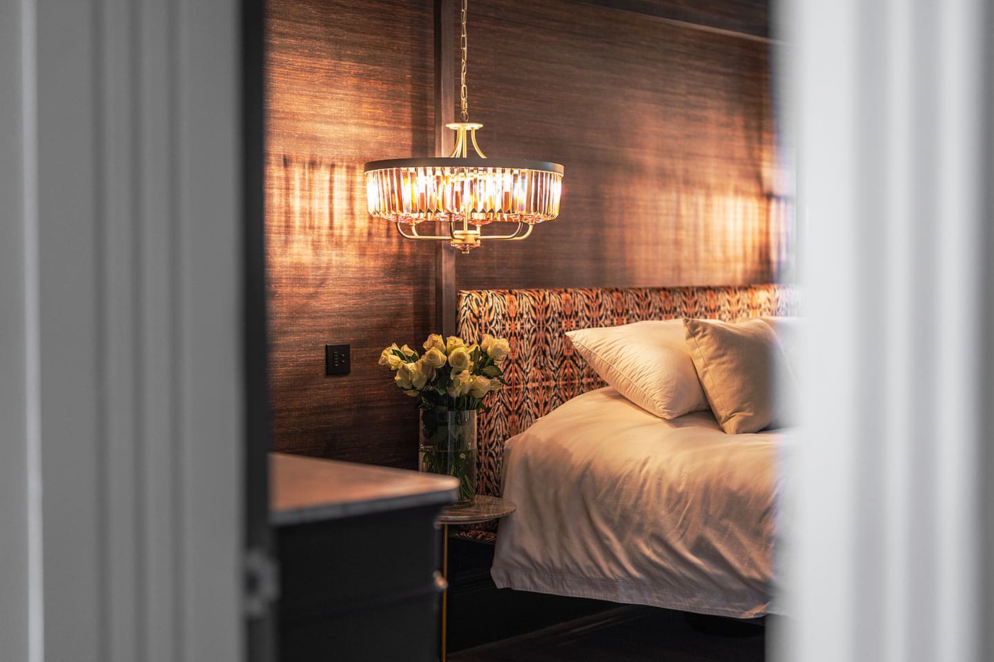 Luxurious master bedroom featuring cozy bedding, ambient lighting, and modern wooden accents for a r.