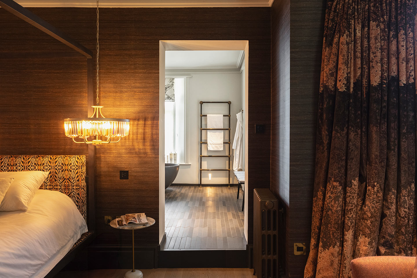 Luxurious master bedroom featuring warm lighting, modern furnishings, and cosy textiles.