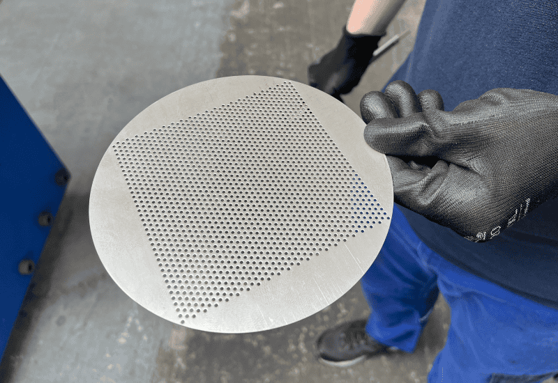 A person holding a metal disc with a hole in it.