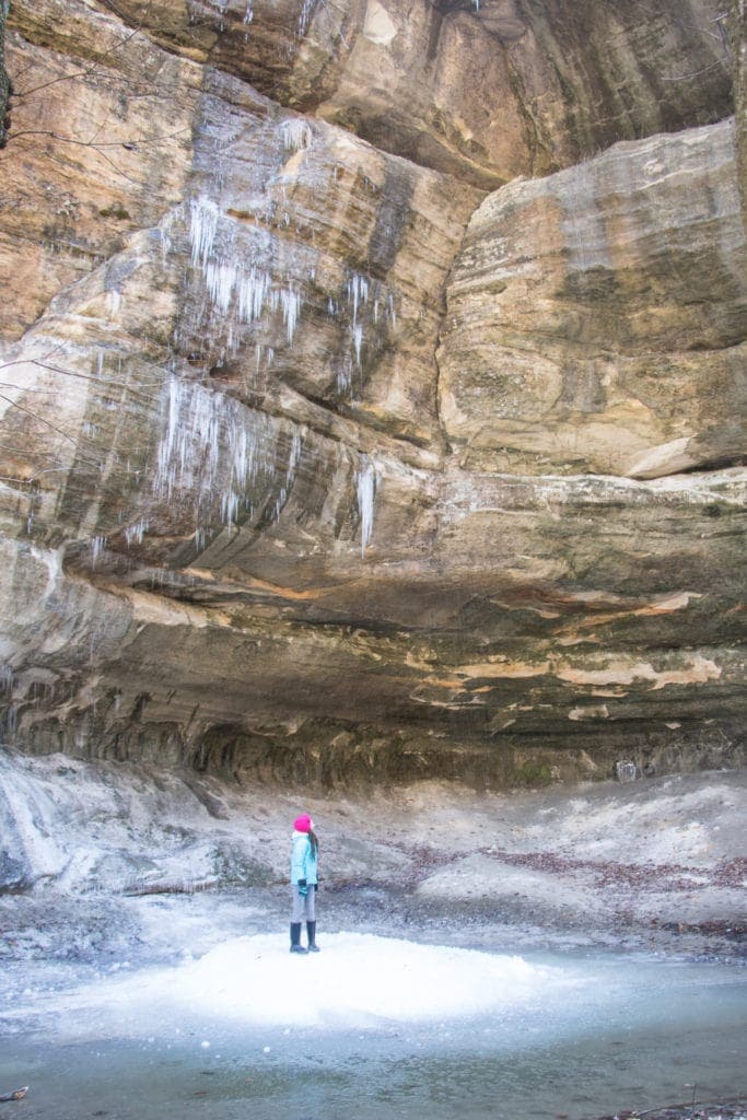 The Best Funny Hiking Quotes For Instagram (Captions + Puns Too) Article Title: Funny Hiking Quotes for Instagram.
Picture description: Starved Rock in the winter. Girl standing in a frozen canyon with large icicles everywhere.