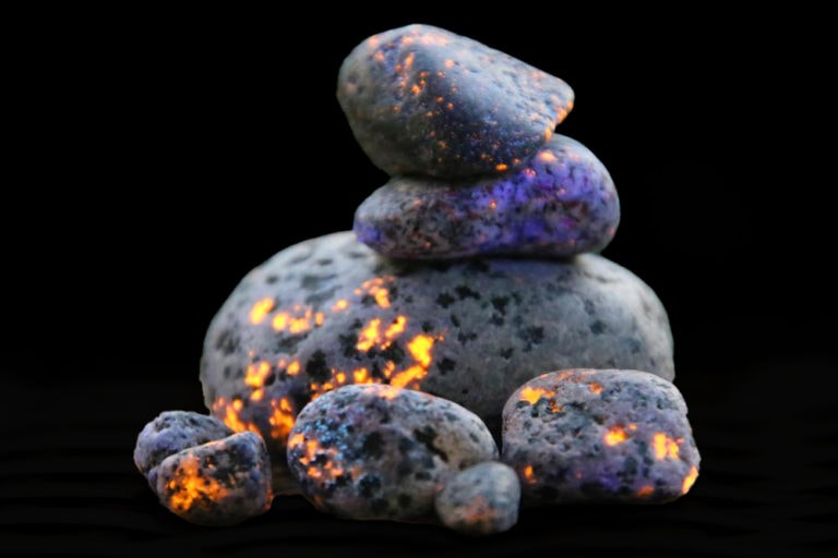 Yooperlite rocks glowing under a UV flashlight