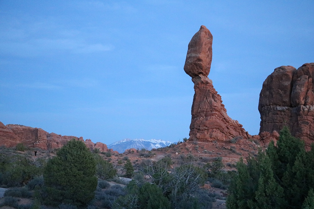 Utah National Parks Road Trip – The Perfect Itinerary A view of Balance Rock in Arches with mountains in the background