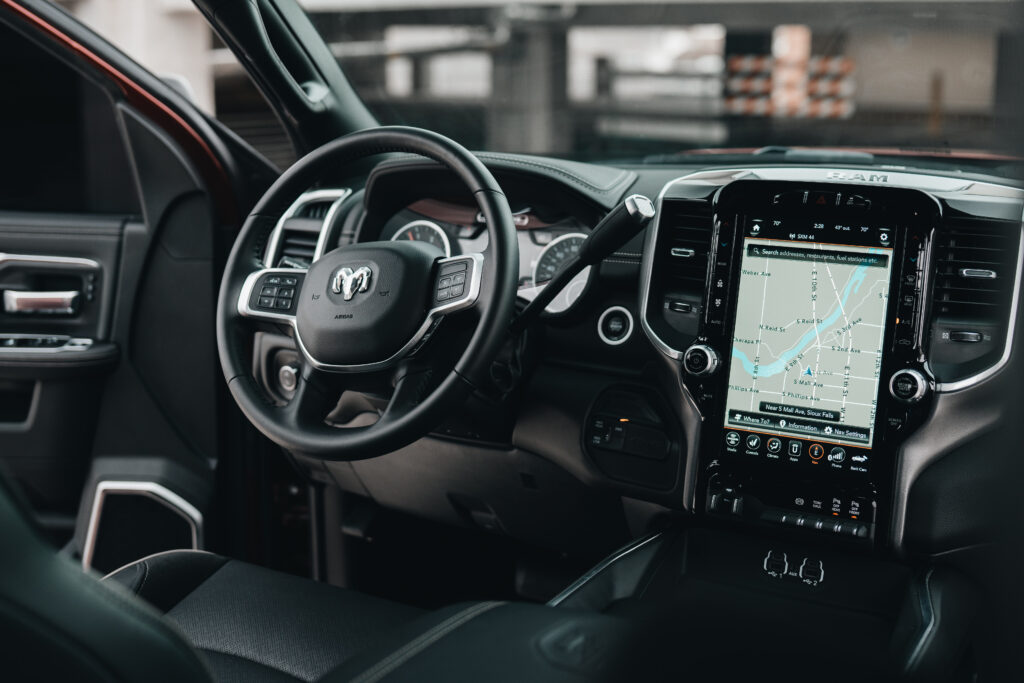 A Stress-Free Family Road Trip Packing List A picture of the inside of a car. The car has a black interior with black leather and a large technology display.