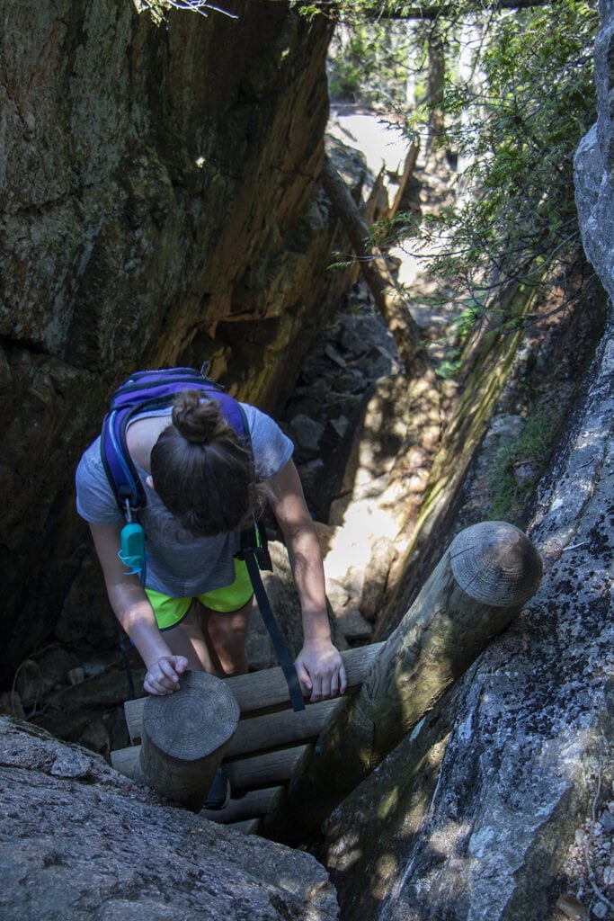Best Hikes in Acadia National Park + Tips Climbing down the ladder on Pemetic Mountain Trail in Acadia.