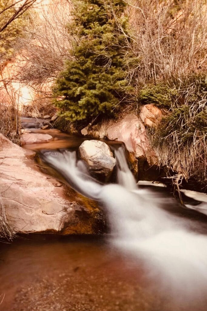 Kanarra Falls: Hike Utah’s Best Slot Canyon A tiny but beautiful waterfall on the way to the slot canyon. The cold, crystal clear water flows around a large boulder making it seem like its two waterfalls.