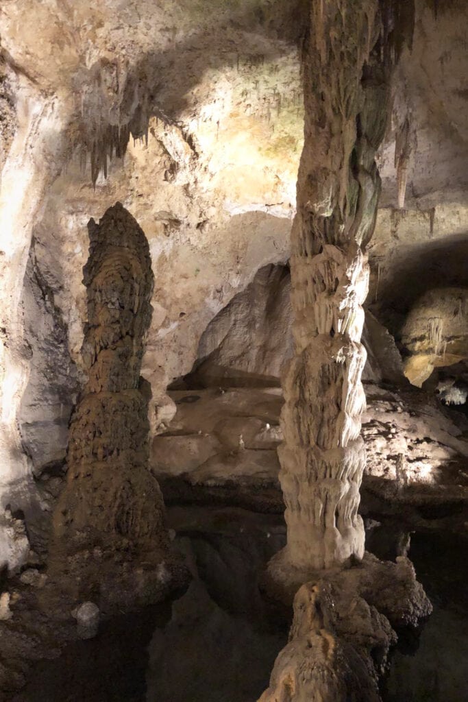 Discover the Funnest National Parks for Kids Interior of Carlsbad Caverns, showcasing giant limestone pillars. Illuminated cave formations create a mesmerizing underground landscape in the heart of the park.