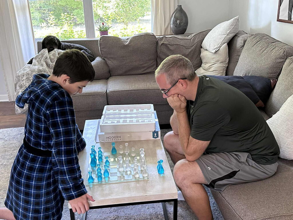 Playing chess inside on a rainy day — a cozy summer bucket list activity.