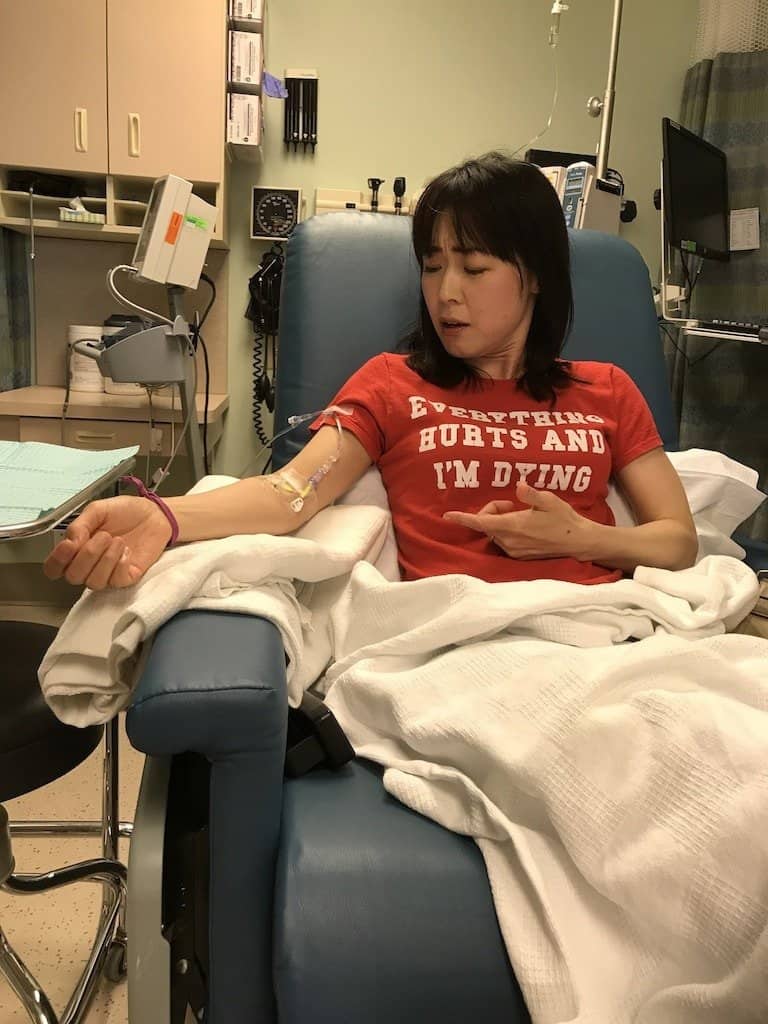 A woman receiving medical treatment in a hospital setting, demonstrating compassionate healthcare support. Taki Soma and Michael Oeming share their multiple sclerosis story.