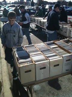 People shopping at a comic book charity event outdoors.