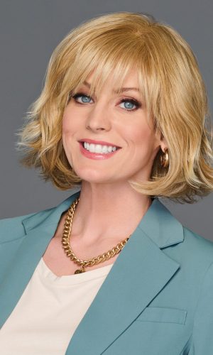 Woman with blonde wig, smiling, promoting positivity and confidence.