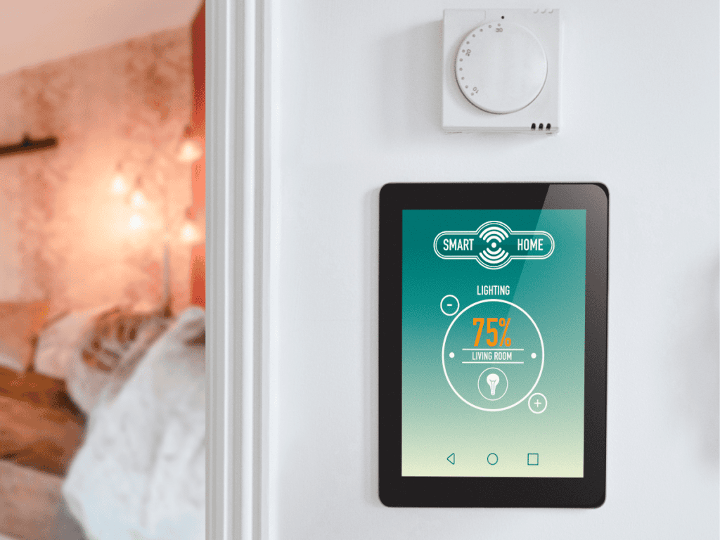 A smart HVAC system control display is mounted on the wall near a thermostat, showing lighting settings at 75% brightness for the living room. In the background, a softly lit room hints at the rising trend of integrated home technologies.