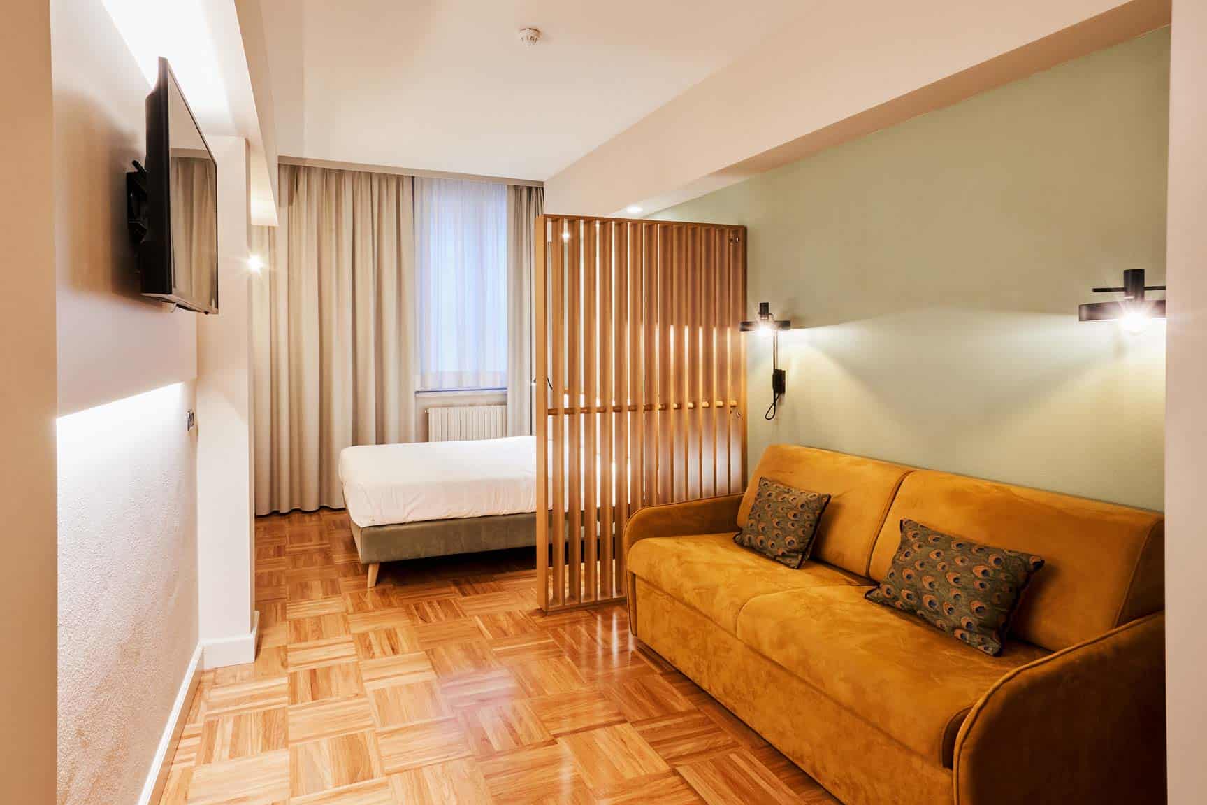 Suite Junior Classic con soggiorno e letto confortevole.