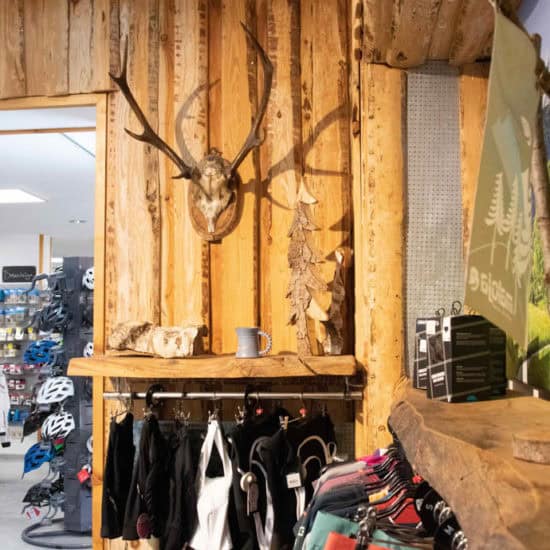 Rustikale Wanddekoration mit Hirschgeweih und Holzpaneelen im Radsportgeschäft.