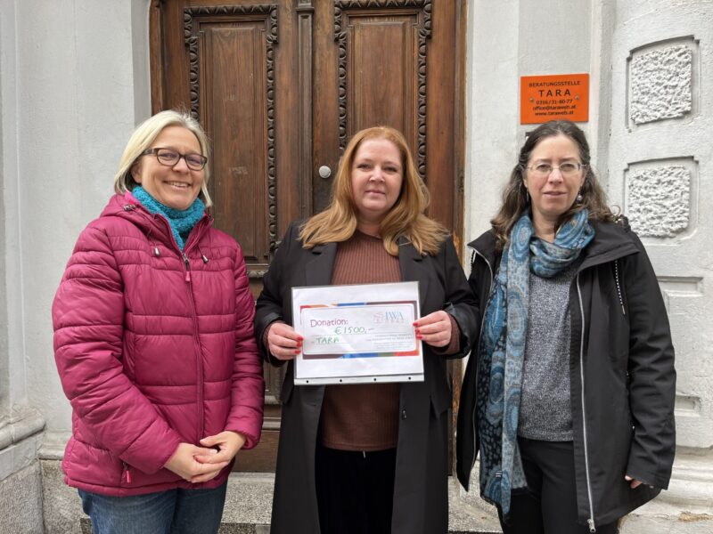 Three women in front of a building