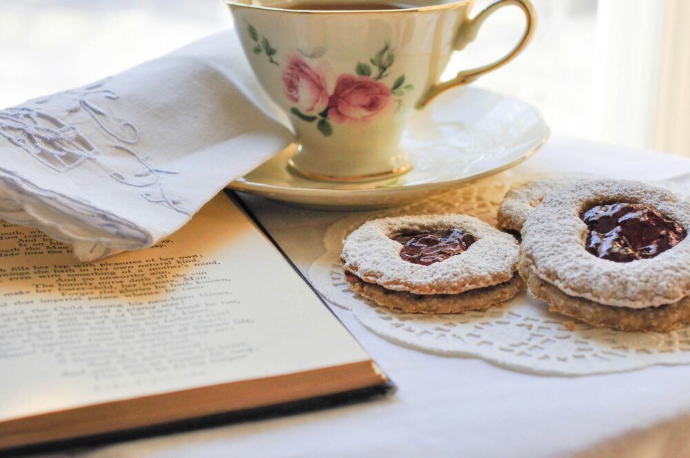 A tea cup, cookies, and a book