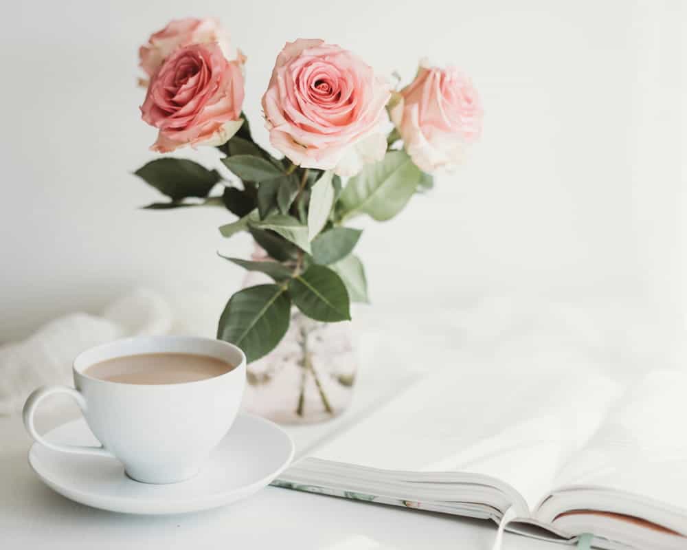 A cup of tea and a vase of roses