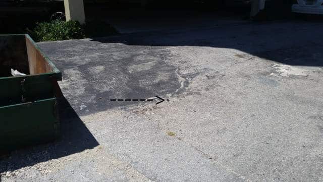 metal rod sticking out of the ground in parking lot