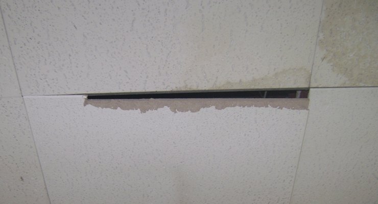 Ceiling tile with water stain and gap between the adjacent tile