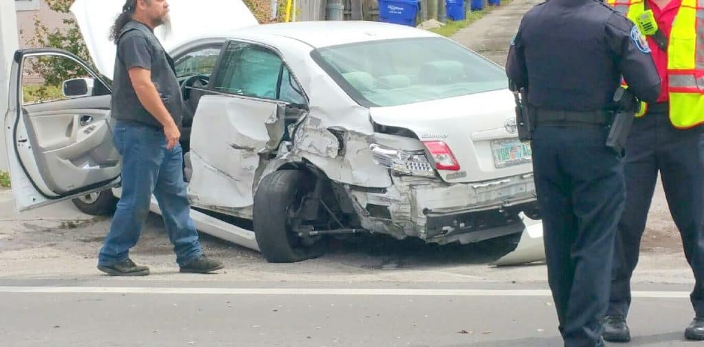 damage to rear and driver side of car. car tire is blown and turned to the side.