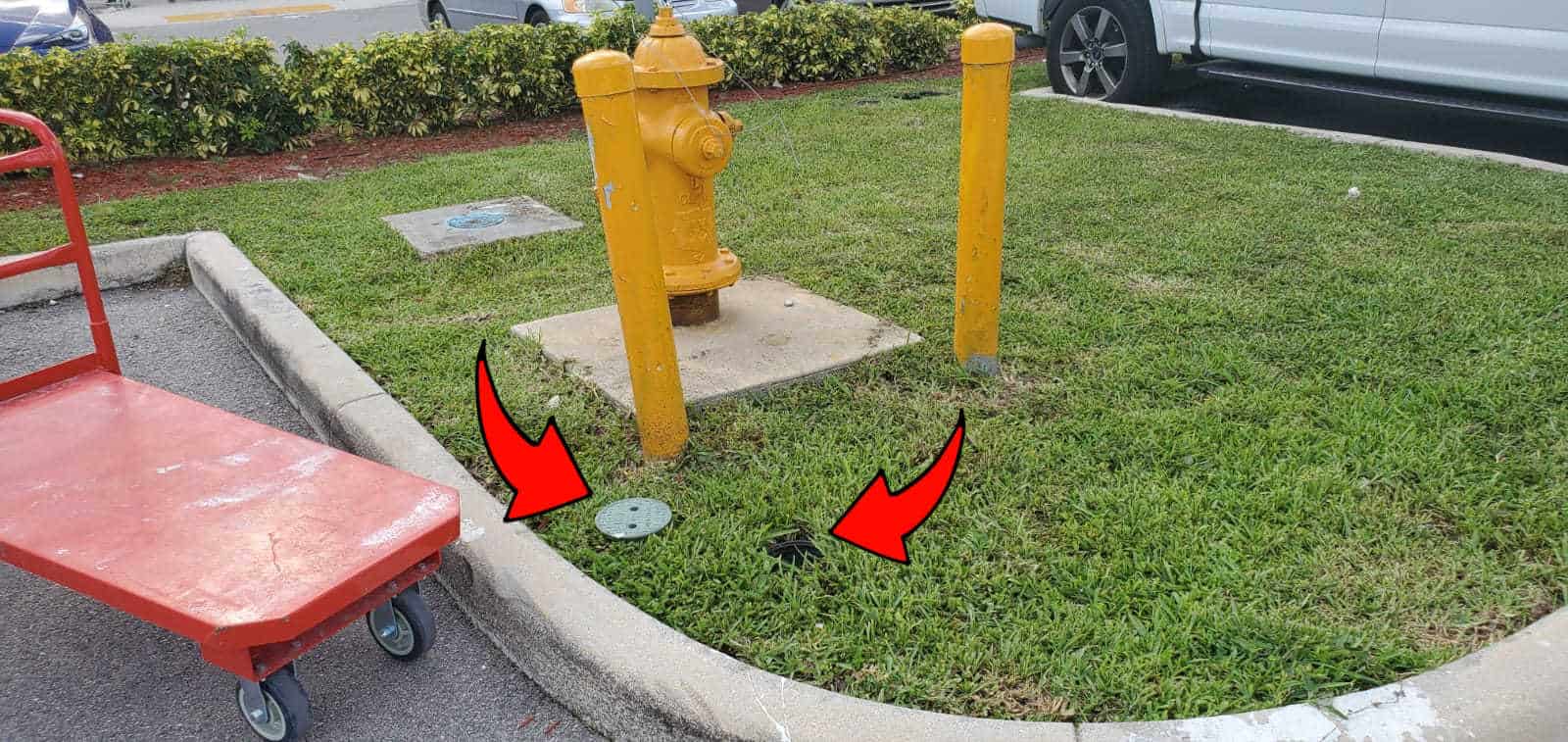 arrows pointing at the cover of an irrigation control valve laying in the grass, next to the uncovered irrigation control valve.