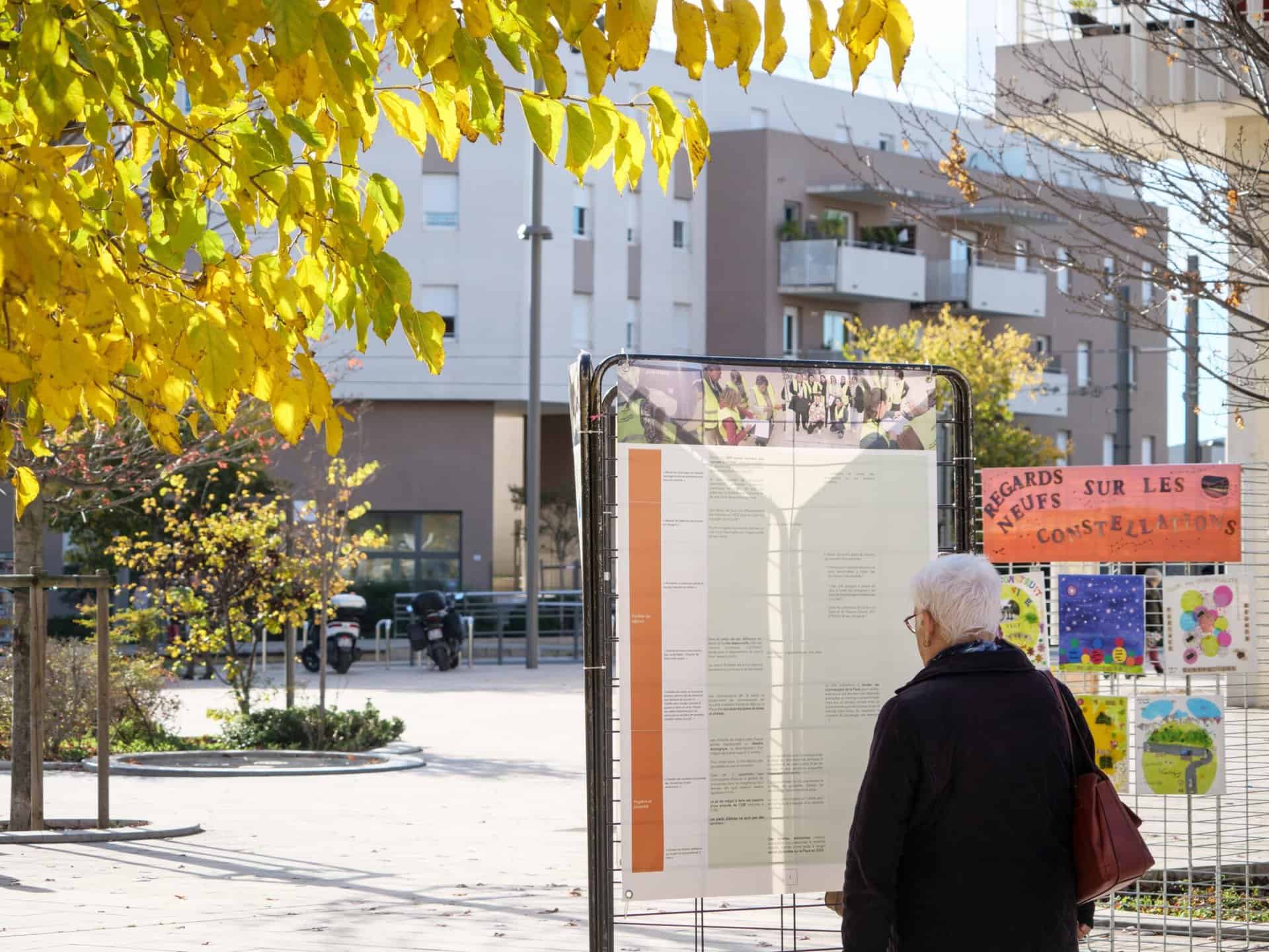 Habitant de Juvignac lisant un panneau informatif issu de la démarche citoyenne sur l'insécurité