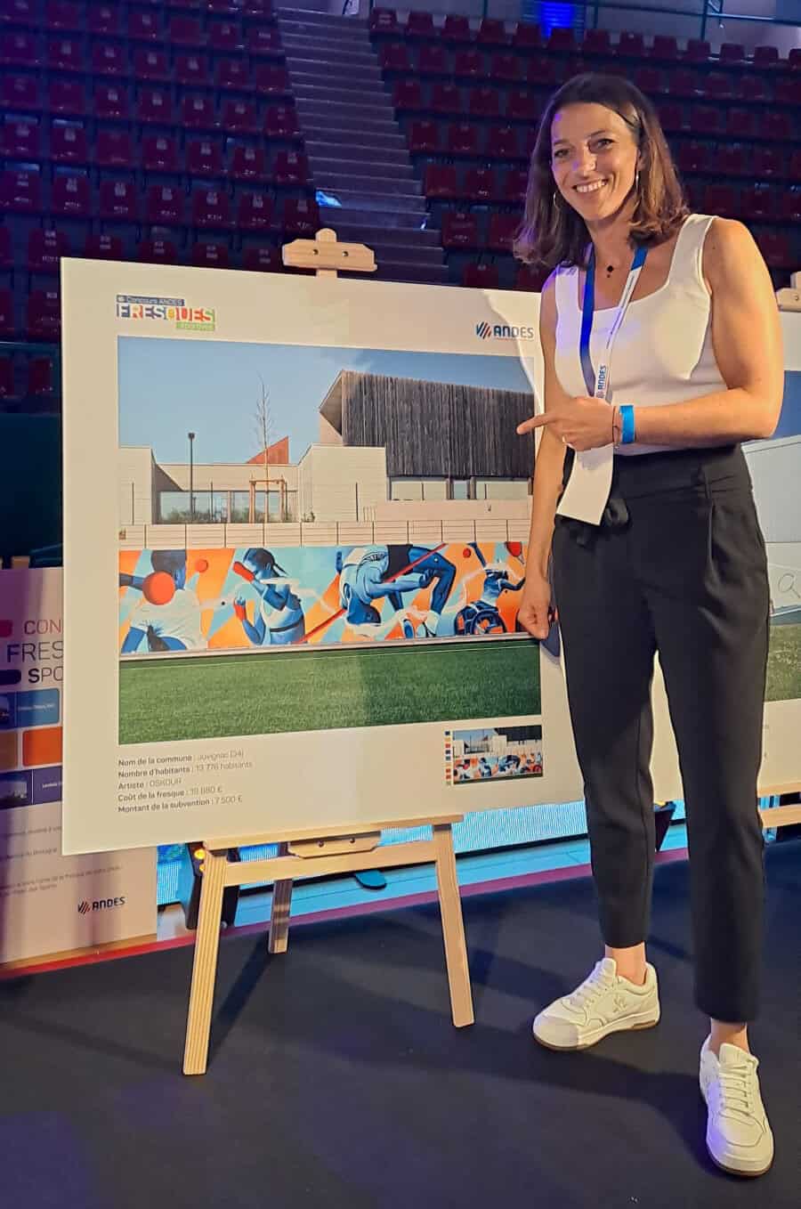 Marie-Delphine Parpillon, conseillère municipale déléguée à la Vie associative et au Sport-Santé pour tous, devant la fresque lauréate du concours