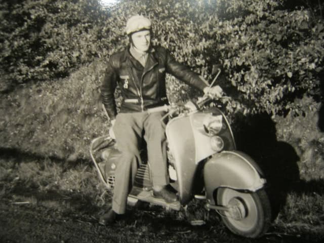 Mann auf Vespa in früheren Jahren, nostalgisches Schwarz-Weiß-Foto.
