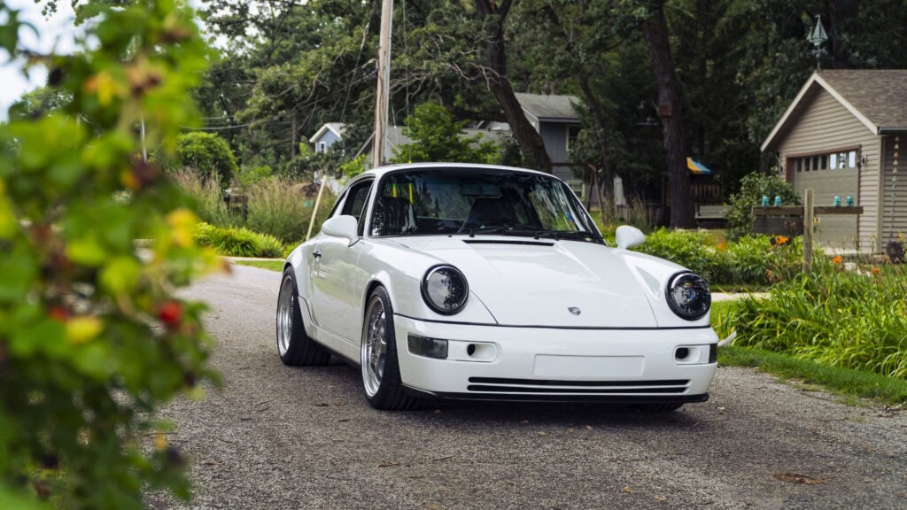 Classic white 1993 Porsche 964 sports car on a scenic road.