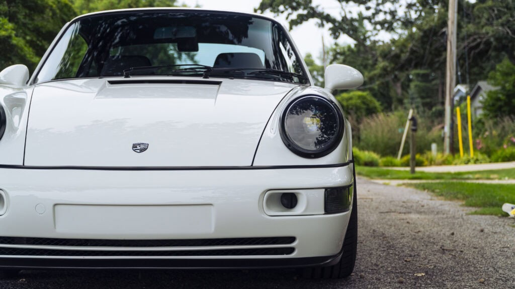 Classic 1993 Porsche 964 sports car in white with round headlights.