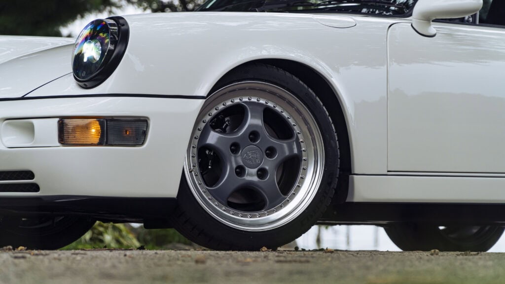 Close-up of a white 1993 Porsche 964 with black alloy wheel and tire.