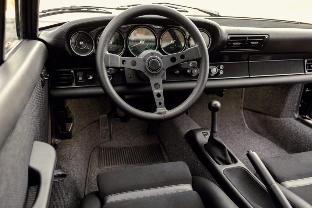 Interior of a classic 1989 Porsche 964 with vintage dashboard and manual gear shift.