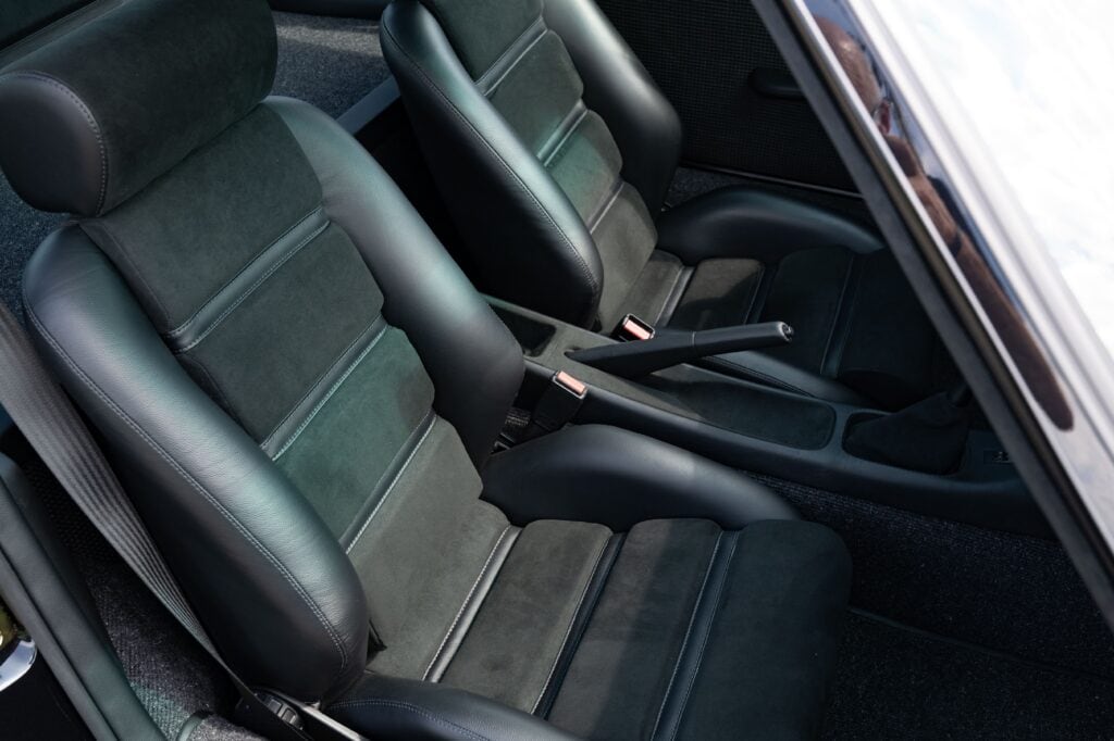Close-up of the black leather and fabric seats inside a 1989 Porsche 964.