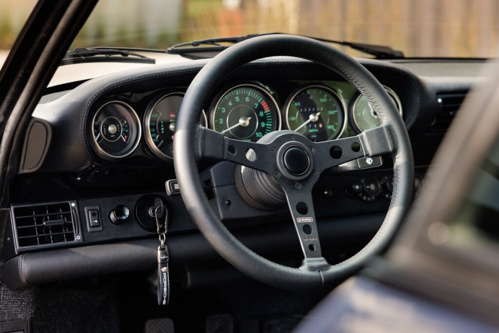 Dashboard and steering wheel of a 1989 Porsche 964 sports car.
