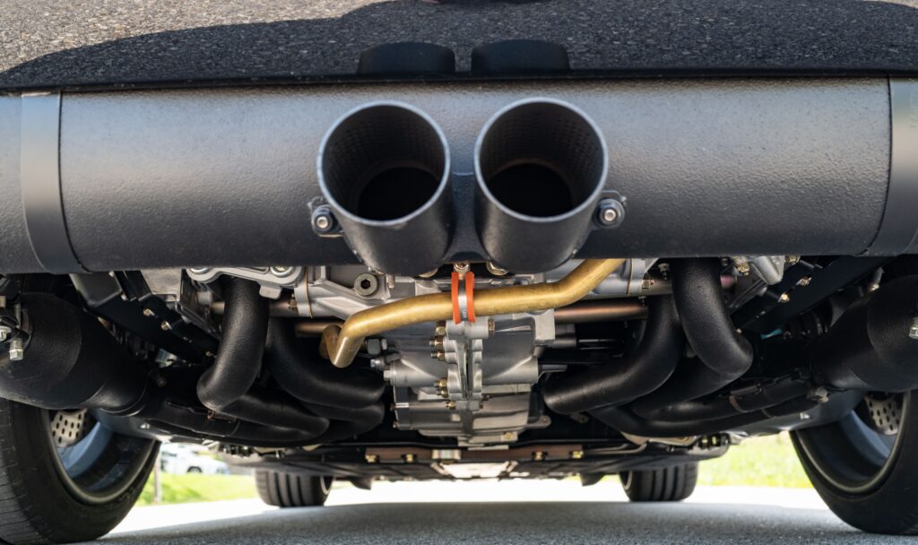 Close-up of Porsche 964 dual exhaust pipes and undercarriage.
