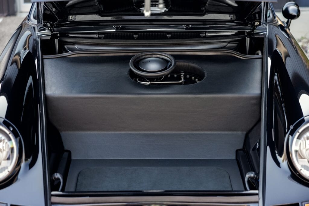 Open trunk of a 1989 Porsche 964 showing custom audio system with subwoofer.