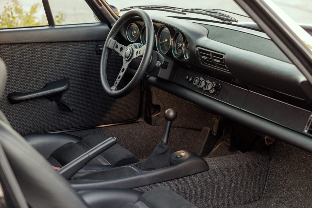 Interior view of a 1989 Porsche 964 with vintage dashboard and manual transmission.