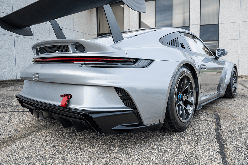 Silver Porsche 911 GT3 Cup 992 parked outside with aerodynamic design features.