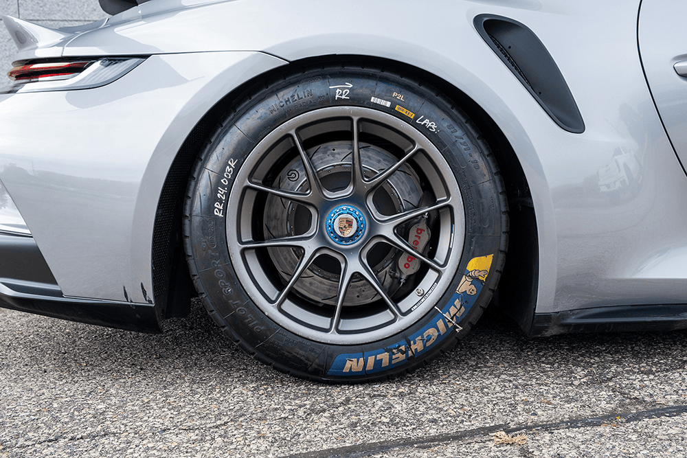 Close-up of a Porsche 911 GT3 Cup 992 wheel and tire with racing branding.